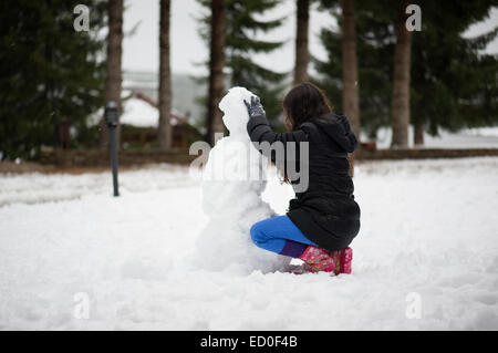 Girl making a snowman Stock Photo