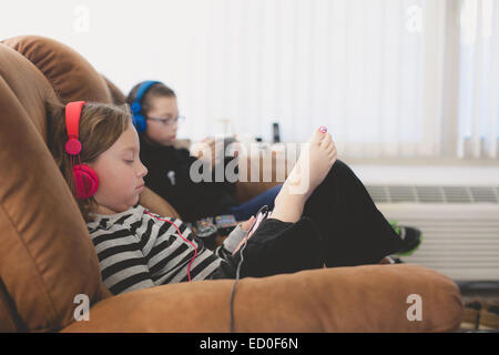 Brother and sisters listening to music Stock Photo