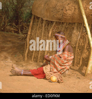 Maasai girl making colourful necklace, The Maasai Mara National Reserve, Narok County, Kenya Stock Photo