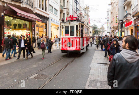 Istanbul, Turkey - November 14, 2014: A red tram makes its way alongside shoppers crowding İstiklal Avenue (Independence Avenue) Stock Photo