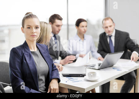 businesswoman in office with team on the back Stock Photo