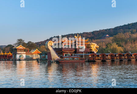 Hangzhou, China - December 5, 2014: Chinese wooden recreation boats and Dragon ship are moored on the West Lake. Famous park in Stock Photo