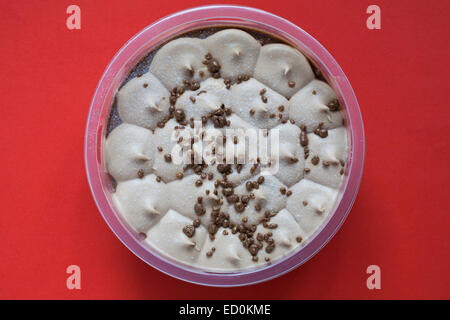 Milk chocolate & caramel cheesecake isolated on red background Stock Photo