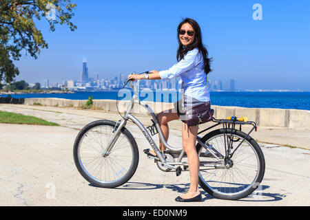 Young Asian woman riding her bike at Lake Michigan in the South Side of Chicago, IL, USA. Stock Photo