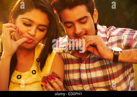 2 indian couple park Eating Chocolate Stock Photo