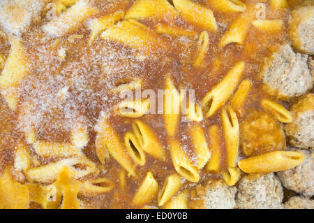 A very close view of a frozen TV dinner of penne pasta in a tomato sauce with meatballs. Stock Photo
