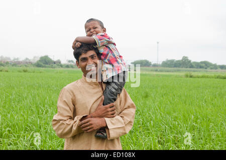 indian rural father with child field fun Stock Photo