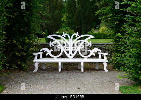 White garden seat seating three seater wood wooden bench gardening feature furniture features RM Ireland ornate design Stock Photo