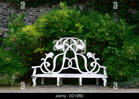 White garden seat seating three seater wood wooden bench gardening feature furniture features RM Ireland ornate design Stock Photo