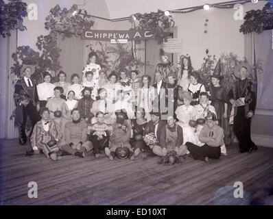 Antique, circa 1902 image, group photo at the Halloween Party of the Chippewa Athletic Club, in costumes and holding pumpkins, in Dorchester, Boston, Massachusetts, USA. Stock Photo