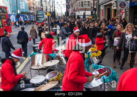 London, UK. 23rd Dec, 2014. Dubbed by retailers as the 'Golden Hour' thousands of shoppers use their lunch hour to do some last minute Christmas shopping in London's West End. PICTURED: A steel band plays Christmasd songs outside Bond Street station. Credit:  Paul Davey/Alamy Live News Stock Photo