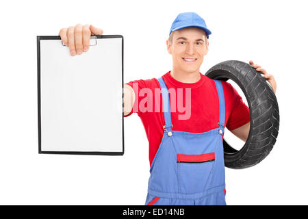 Male mechanic holding a tire and a clipboard isolated on white background Stock Photo
