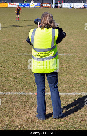 a professional sports photographer taking photographs at a junior rugby game Stock Photo