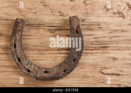 Horseshoe and two horseshoe nails on wooden plank Stock Photo - Alamy