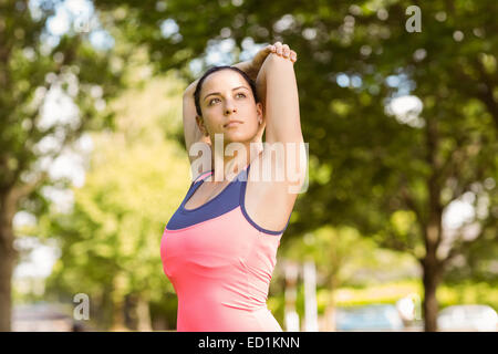 Fit brunette in sportswear stretching Stock Photo