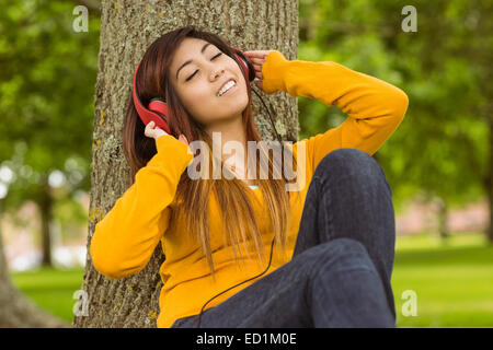 Relaxed woman enjoying music in park Stock Photo