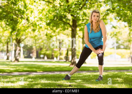 Fit blonde stretching on the grass Stock Photo - Alamy