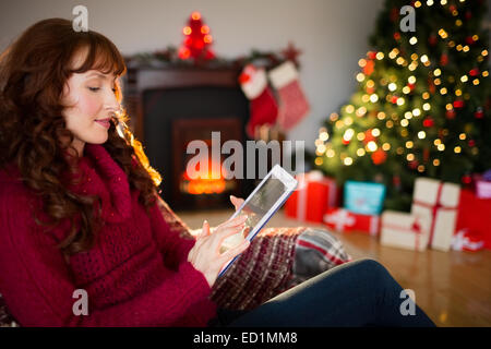 Redhead using digital tablet at christmas Stock Photo