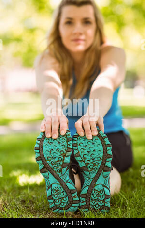 Fit blonde stretching on the grass Stock Photo - Alamy