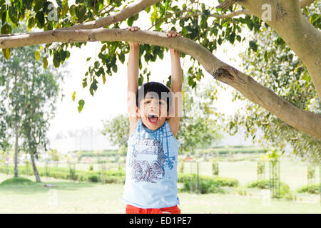 1 indians Child boy park Hanging Tree Trunk Stock Photo