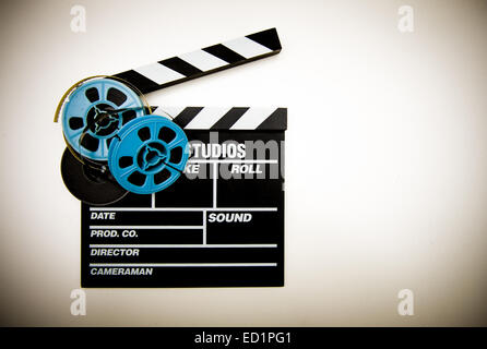 Clapper board with 8mm film reels in white background and vintage color effect Stock Photo