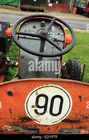 Close up of red antique tractor seat and wheel Stock Photo