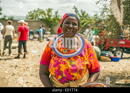 Traditionally dressed african woman from the masai tribe selling merchandise  in the Masai Central Market of Mto Wa Mbu Stock Photo