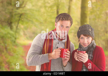 Composite image of couple both having warm drinks Stock Photo
