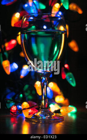 A glass of wine or champagne for a celebration on a table with fairy lights in the background at New Year or Christmas. Stock Photo