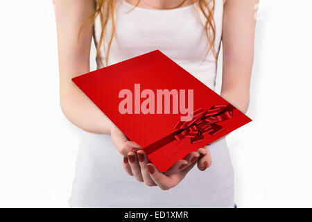 Composite image of woman holding red and white gift Stock Photo