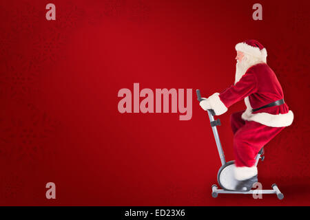 Composite image of santa uses a home trainer Stock Photo