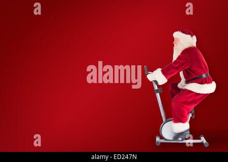 Composite image of santa uses a home trainer Stock Photo