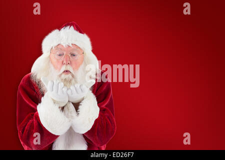 Composite image of santa claus blows something away Stock Photo