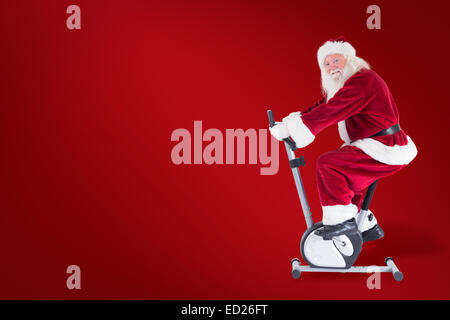 Composite image of santa uses a home trainer Stock Photo