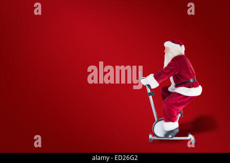 Composite image of santa uses a home trainer Stock Photo