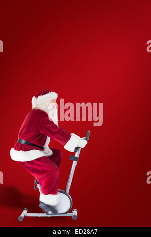 Composite image of santa uses a home trainer Stock Photo