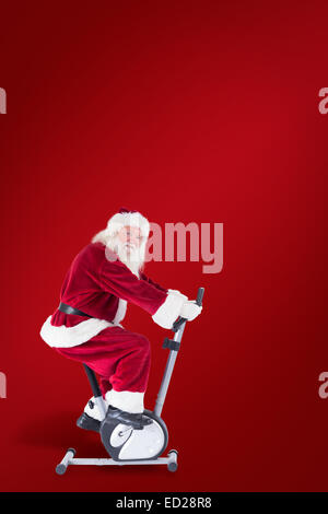 Composite image of santa uses a home trainer Stock Photo