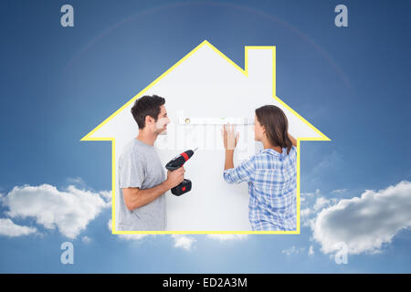 Composite image of man and his wife doing diy together Stock Photo