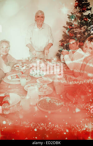 Composite image of happy grandfather carving the christmas turkey Stock Photo