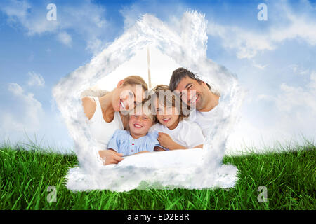 Composite image of happy family reading a book on bed Stock Photo