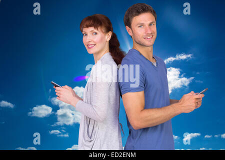 Composite image of couple both sending text messages Stock Photo