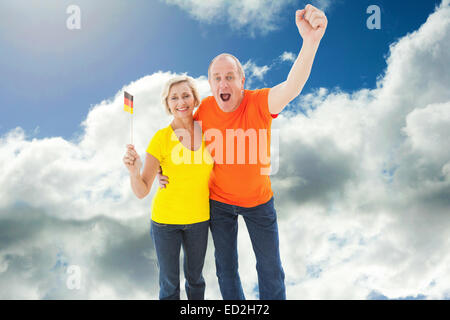 Composite image of happy german couple cheering at camera Stock Photo