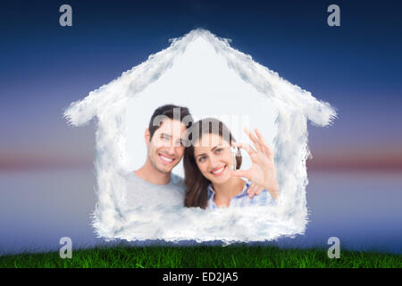 Composite image of woman presenting a silver key Stock Photo