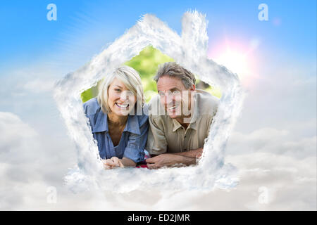 Composite image of couple lying on blanket in park Stock Photo