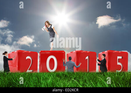 Composite image of businesswoman shouting through megaphone Stock Photo