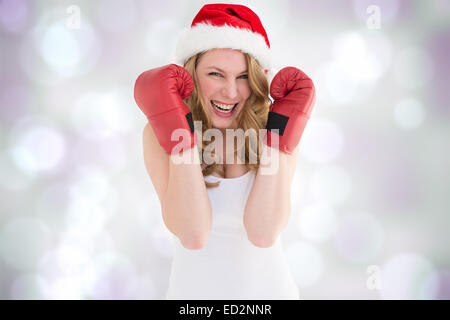 Composite image of blonde woman wearing boxing gloves smiling at camera