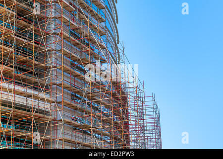 Modern building is under construction, metal scaffolding and sky Stock Photo
