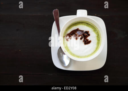 Cup of hot matcha green tea latte with milk cream Stock Photo