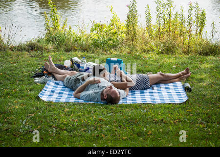 Preston, Lancashire: Couple relaxing by the side of the River Ribble in Preston's Avenham Park Stock Photo