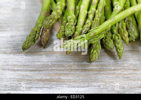 Close up of pile of asparagus; focus on front with shallow depth of field, on rustic white wood Stock Photo